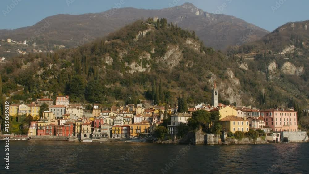 The beautiful shores of Lake Como with the town of Varenna and the Italian Alps in background. View from ferry. The beautiful shores of Lake Como with the town of Varenna and the Italian Alps in background. View from ferry.