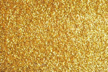 Sprinkle glitter gold dust on a black background with copy space