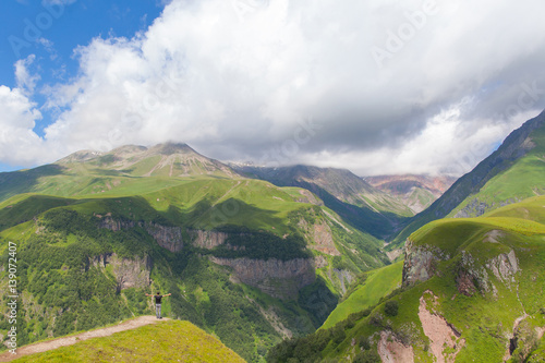 Man standing  on the top of mountain. Caucasus mountains in summer  road from Gudauri to Stepantsminda  Georgia.