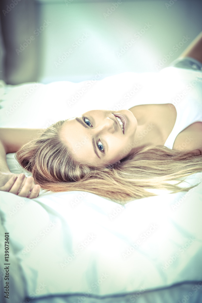 Pretty woman lying down on her bed at home Pretty woman lying down on her bed at home