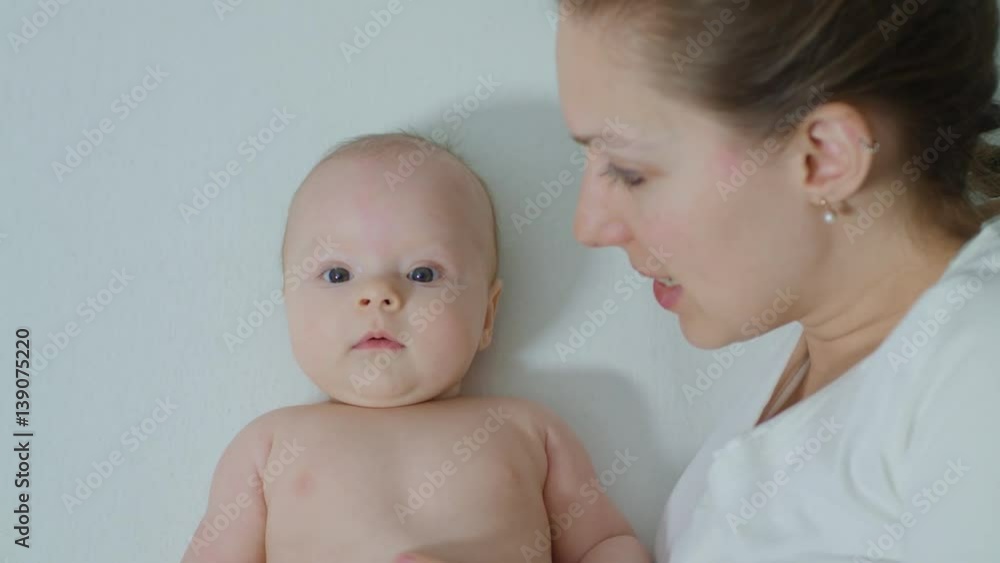 Mother with baby in bed cuddling. Mother and her Newborn Baby. Happy Mother and Baby kissing and hugging. Motherhood Beautiful Happy Family Footage. Slow Motion Mother with baby in bed cuddling. Mother and her Newborn Baby. Happy Mother and Baby kissing and hugging. Motherhood Beautiful Happy Family Footage. Slow Motion