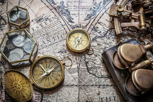 Canvas Print Compass, sextant and old coins on vintage map. Retro style.