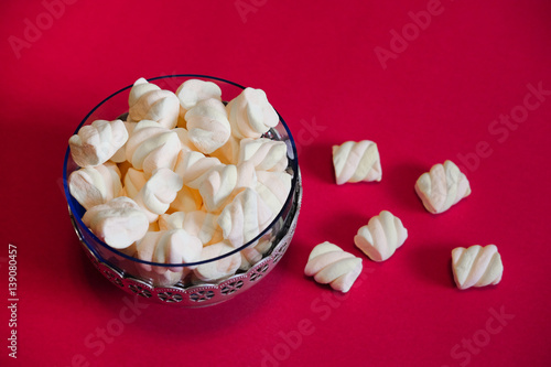 Air marshmallows in glass vintage vase on a red background. The delicious taste of marshmellow in restaurants and cafes.
