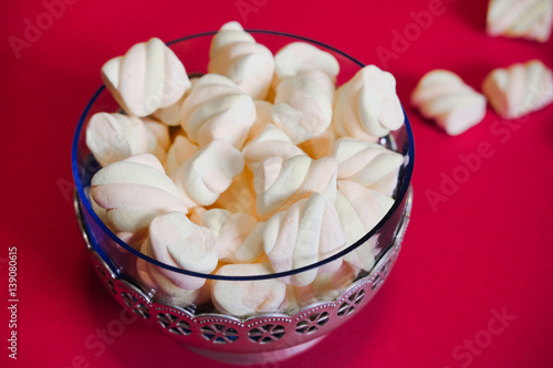 Air marshmallows in glass vintage vase on a red background. The delicious taste of marshmellow in restaurants and cafes.