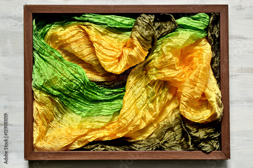 Wooden frame filled with multicolored silk headscarf photo