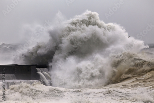 Big stormy wave breaking over pier