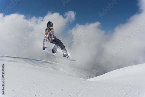 Jumping snowboarder in winter mountain. Extreme sport.