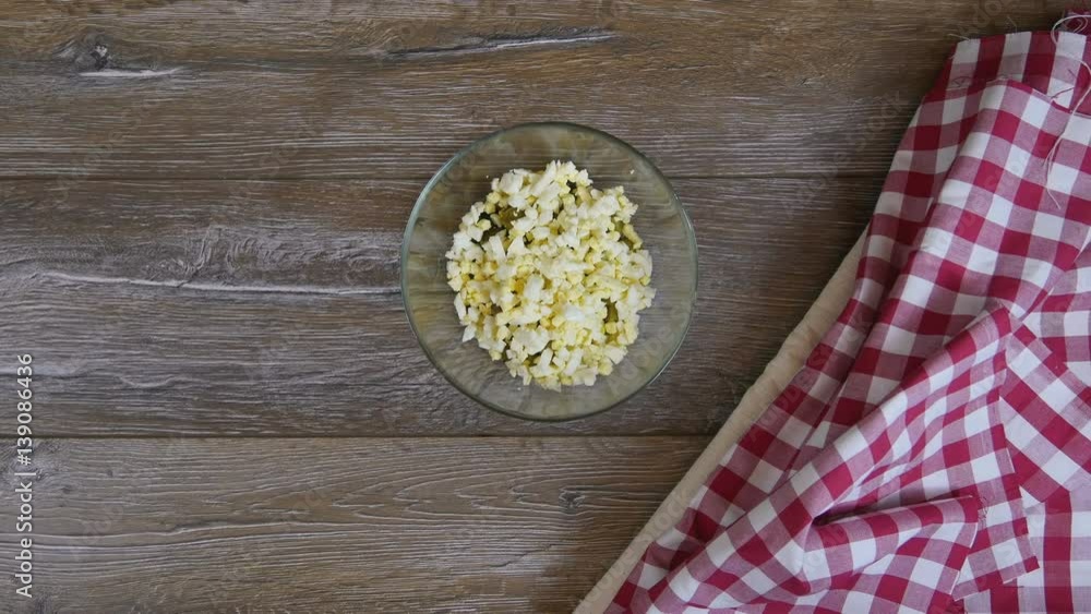 Cook adds eggs to the salad. Top view Cook adds eggs to the salad. Top view