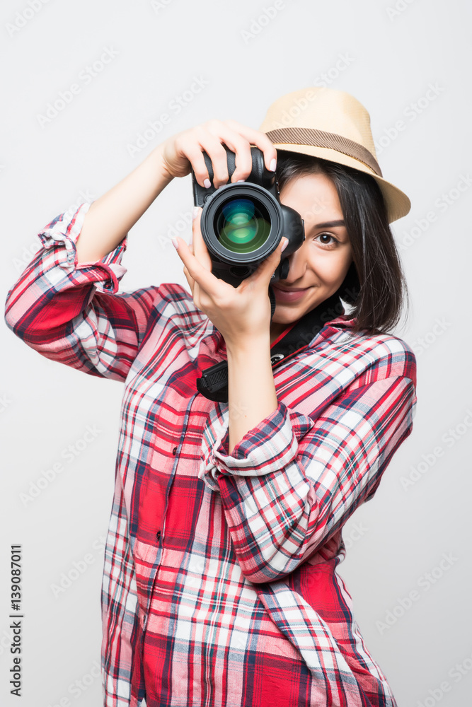 Woman traveler taking picture with camera on grey background Woman traveler taking picture with camera on grey background