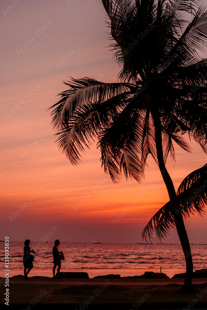 Fototapeta premium Silhouette of coconut tree with Twilight sunset at the beach, background.