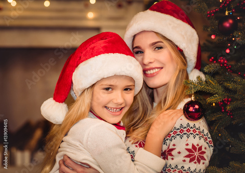 Happy mother and daughter in santa hats