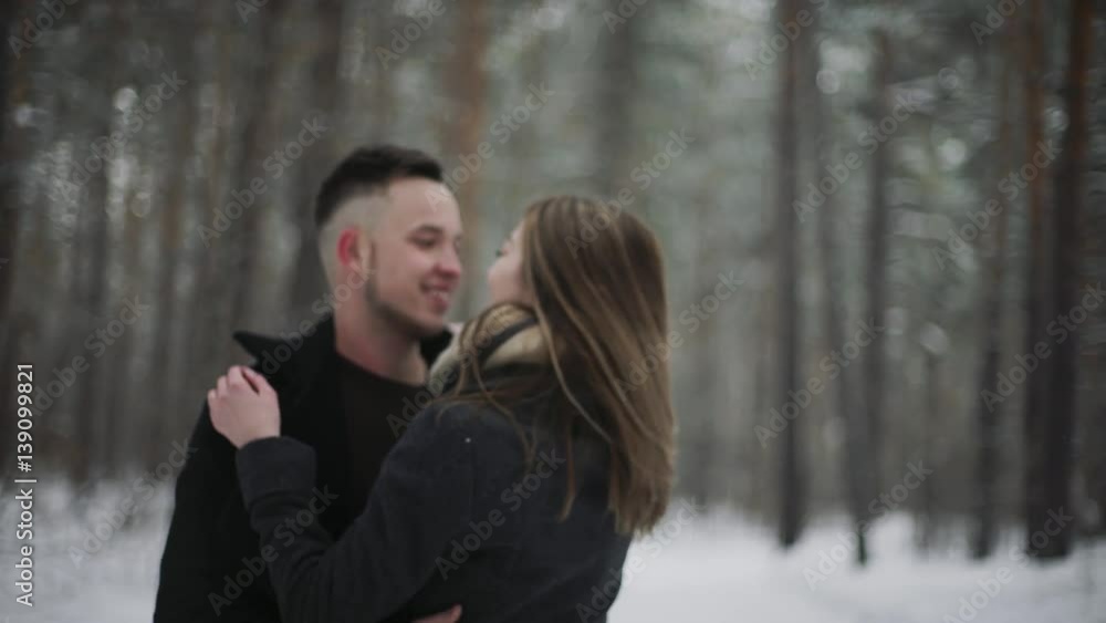 Outdoor happy laughing couple is having a fun in a winter snow forest Outdoor happy laughing couple is having a fun in a winter snow forest