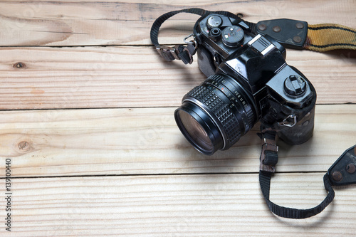 Old retro camera on vintage wooden boards abstract background