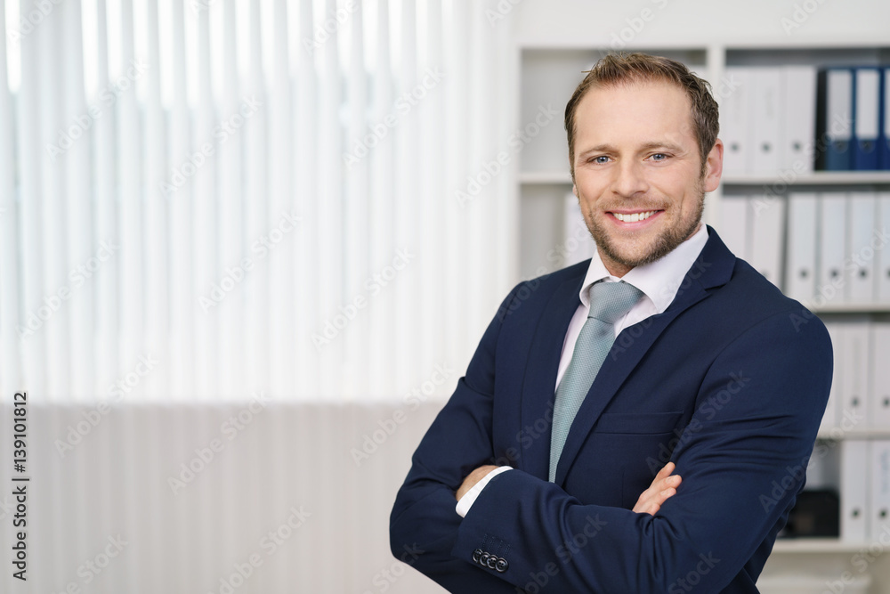 unternehmer steht mit verschränkten armen im büro unternehmer steht mit verschränkten armen im büro