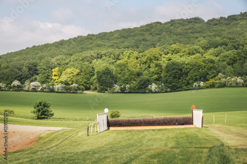 Open landscape with steeplechase horse racing course and hurdles.