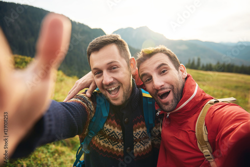 Smiling hikers taking a selfie while trekking in the wilderness