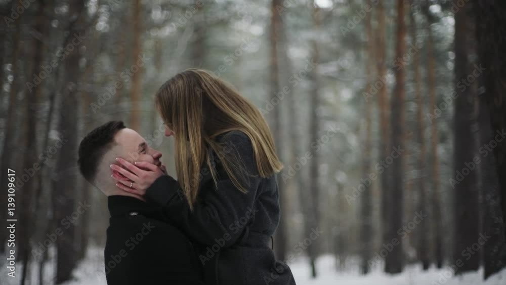 20s Man is lifting his girlfriend and having a fun in a snow winter forest 20s Man is lifting his girlfriend and having a fun in a snow winter forest