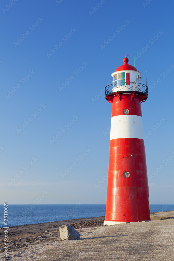 Red and white lighthouse and a clear blue sky