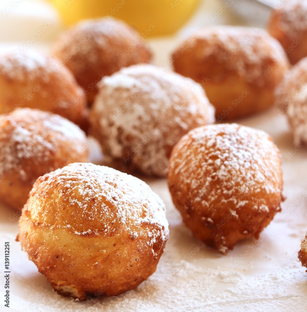 Ricotta Donuts ( Fritters) dusted with powdered sugar on white background, selective focus