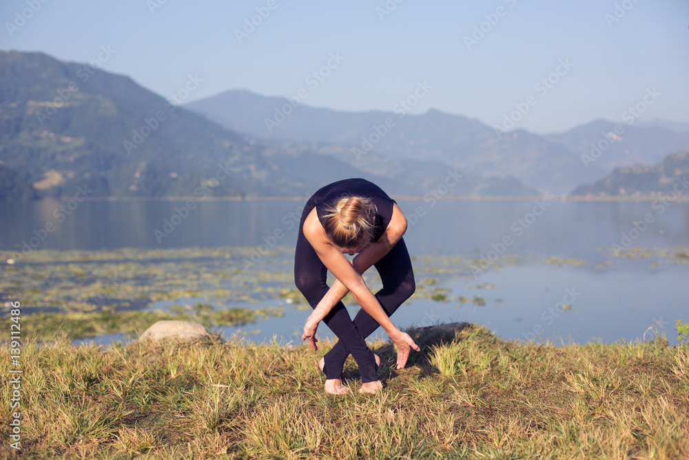 Young woman practicing morning yoga outdoor on mountain lake Young woman practicing morning yoga outdoor on mountain lake