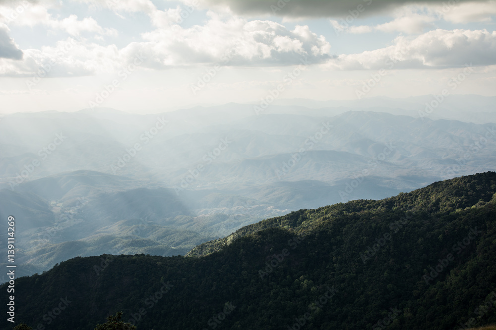 Beautiful sun rays through the clouds over mountains,evening light,Amazing scene Beautiful sun rays through the clouds over mountains,evening light,Amazing scene