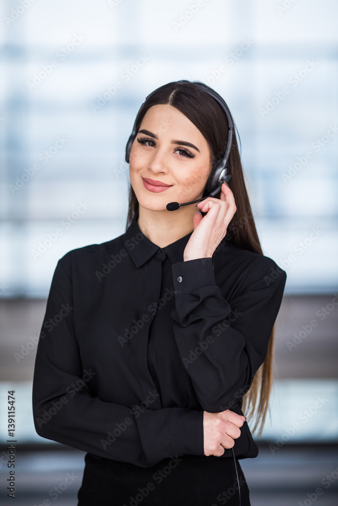 Portrait of happy smiling female customer support phone operator at workplace background Portrait of happy smiling female customer support phone operator at workplace background