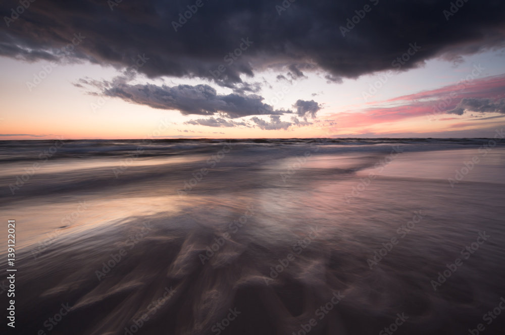 Ocean sunset scene with waves photographed with long exposure