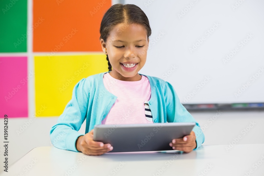 Schoolgirl using digital tablet in classroom Schoolgirl using digital tablet in classroom