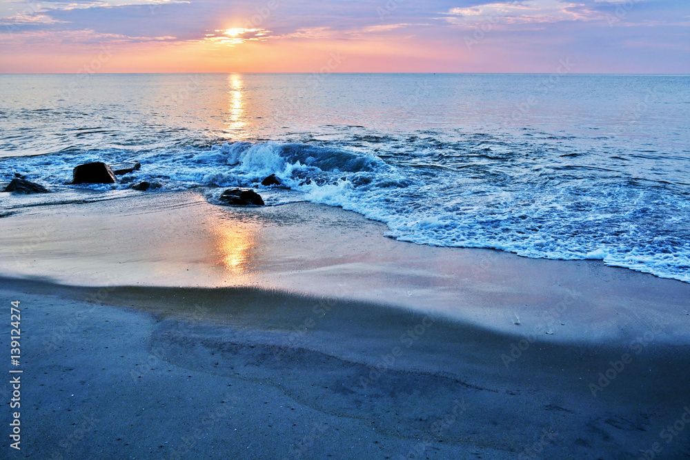 Obraz premium Rock Jetty on Beach Beneath A Summer Sunrise