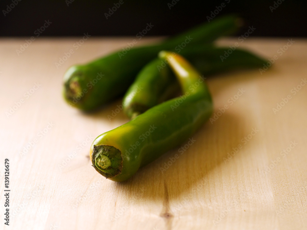 green chili peppers on wooden board, shallow depth of field green chili peppers on wooden board, shallow depth of field