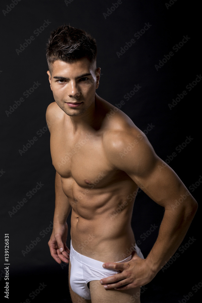 Handsome muscular young man posing in the studio Handsome muscular young man posing in the studio