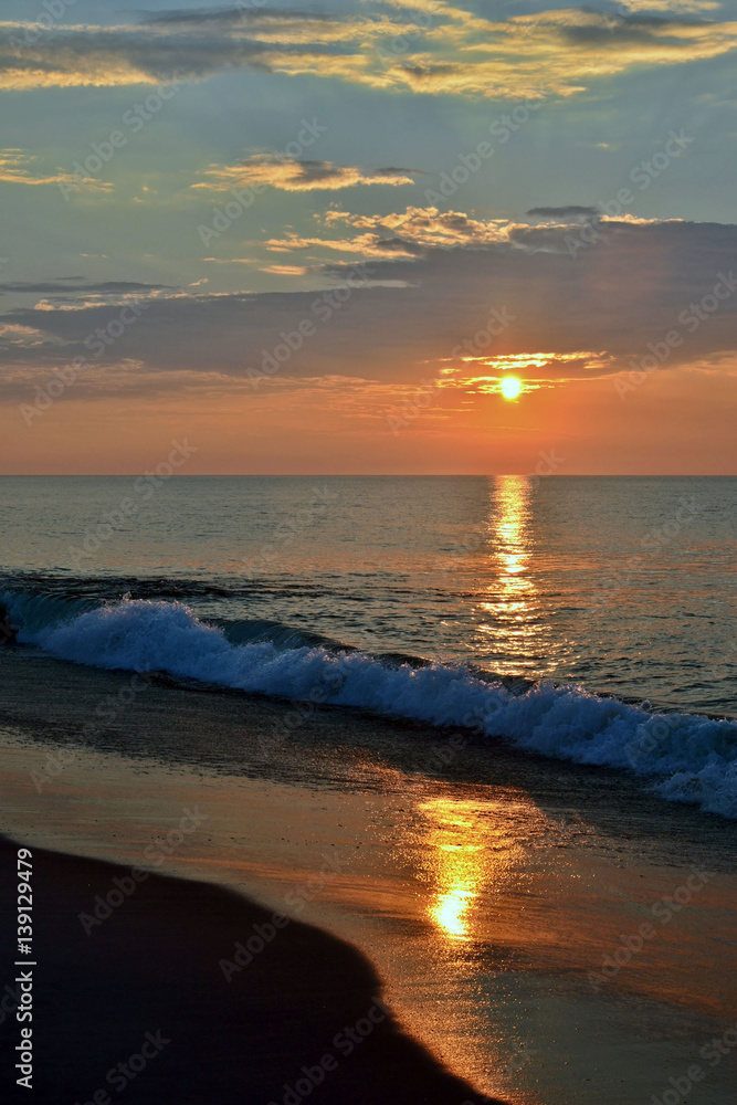 Obraz premium Golden Seashore Sunrise Above Breaking Waves