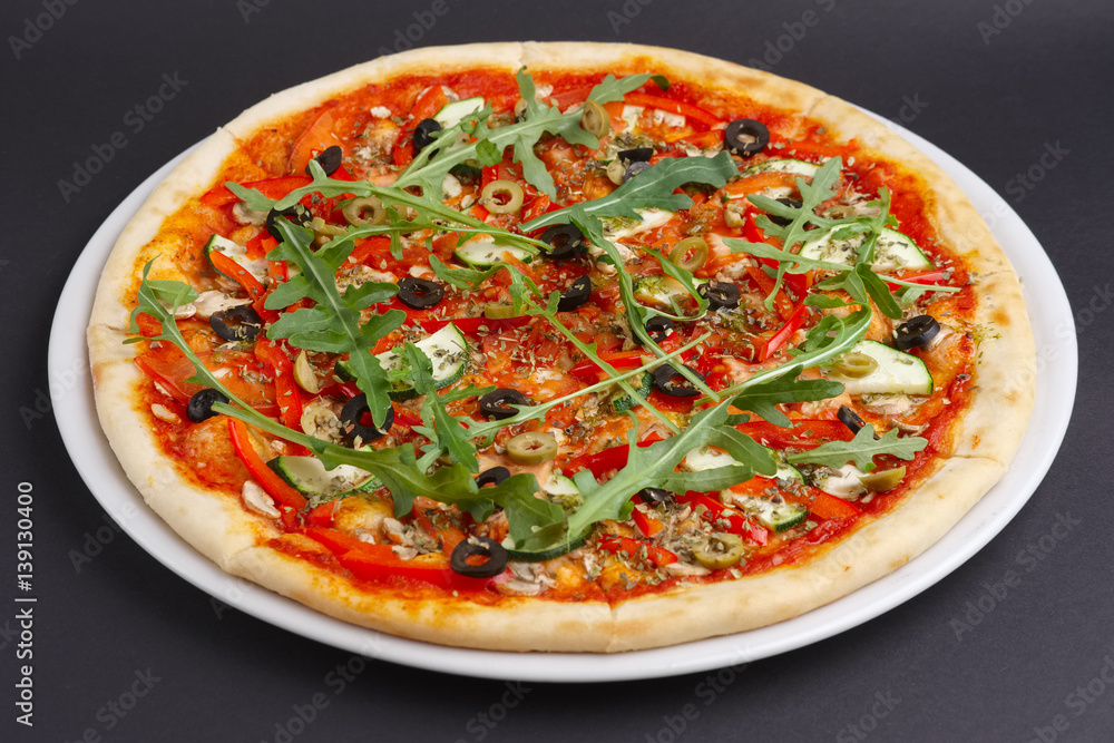Lean pizza Margherita with cheese, arugula, tomato sauce on a white plate. Lean pizza Margherita with cheese, arugula, tomato sauce on a white plate.