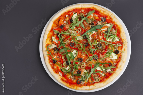 Lean pizza Margherita with cheese, arugula, tomato sauce on a white plate. Space for text.