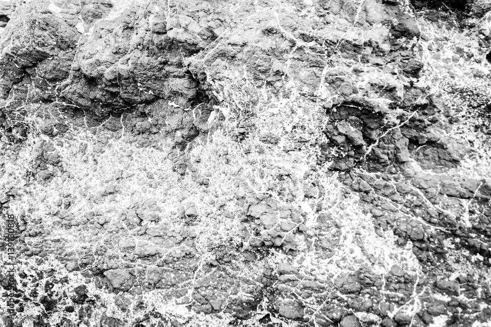 Close up texture of grey stone with cracks in black and white