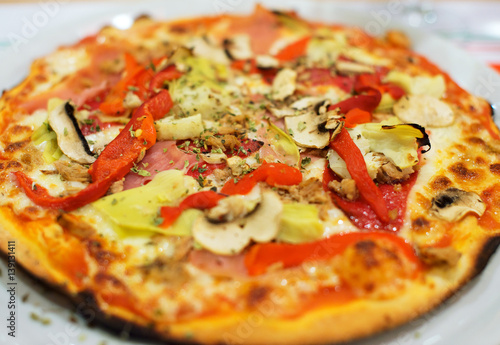 Pizza with ham, paprika and mushrooms.
