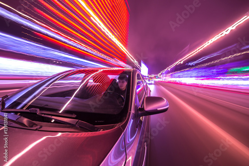 Blurred urban look from fast driving car to back side and driver at winter night. Longexposure shot.