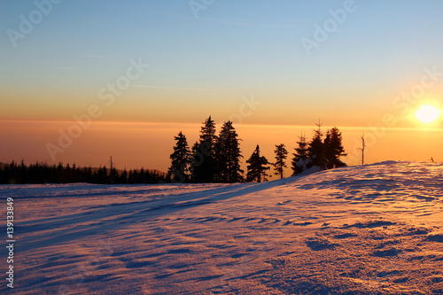 Sunset in the snowy mountains and smog in the valley