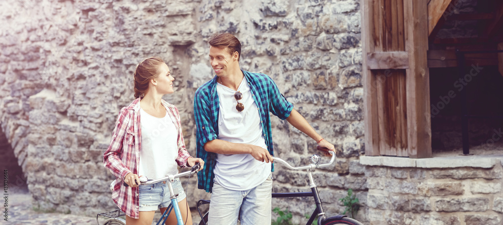 Young couple of hipsters riding a bicycle. Date in old town. Love, relationship, romance concept. Young couple of hipsters riding a bicycle. Date in old town. Love, relationship, romance concept.