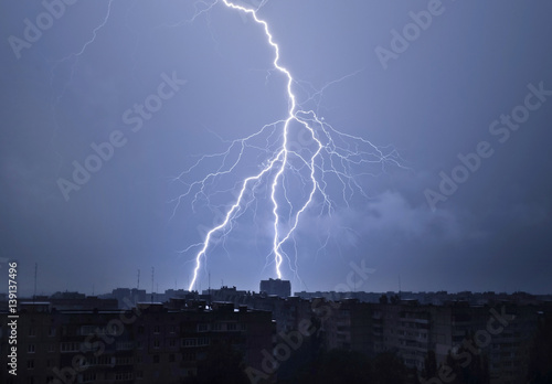 Lightning in the night sky strikes the roof of the house © andrei310