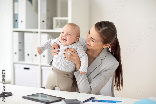 happy businesswoman with baby working at office