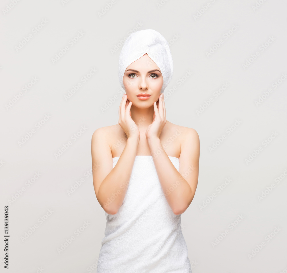 Young, beautiful and natural woman wrapped in towel over grey background. Young, beautiful and natural woman wrapped in towel over grey background.