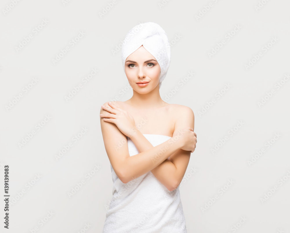Young, beautiful and natural woman wrapped in towel over grey background. Young, beautiful and natural woman wrapped in towel over grey background.