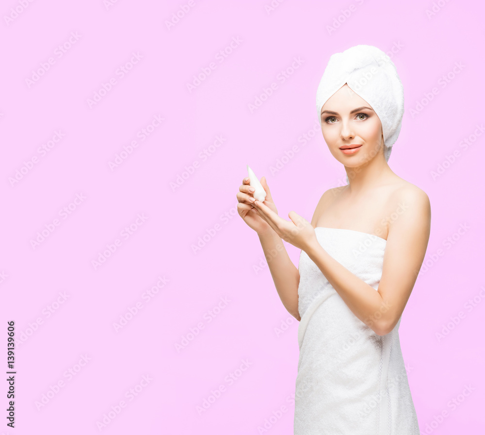 Young, beautiful and natural woman wrapped in towel over pink background. Young, beautiful and natural woman wrapped in towel over pink background.