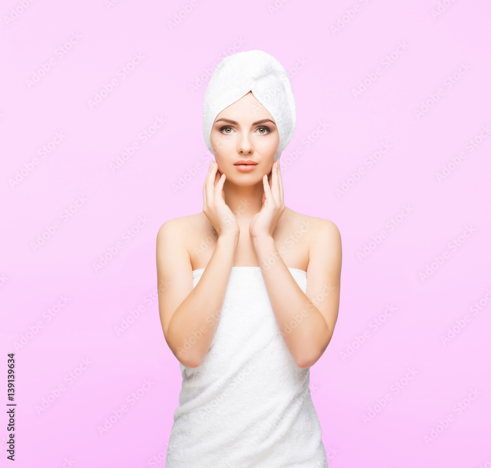 Young, beautiful and natural woman wrapped in towel over pink background. Young, beautiful and natural woman wrapped in towel over pink background.