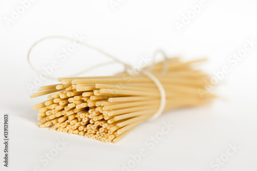 Italian bucatini pasta on white surface