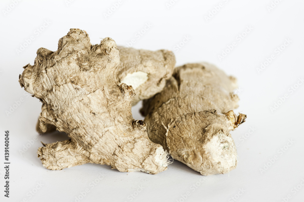 Ginger roots on white surface