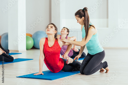 teacher helping with yoga pose indoors