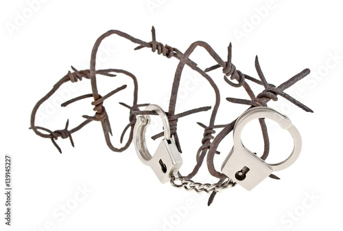 Rusty barbed wire and handcuffs on a white background