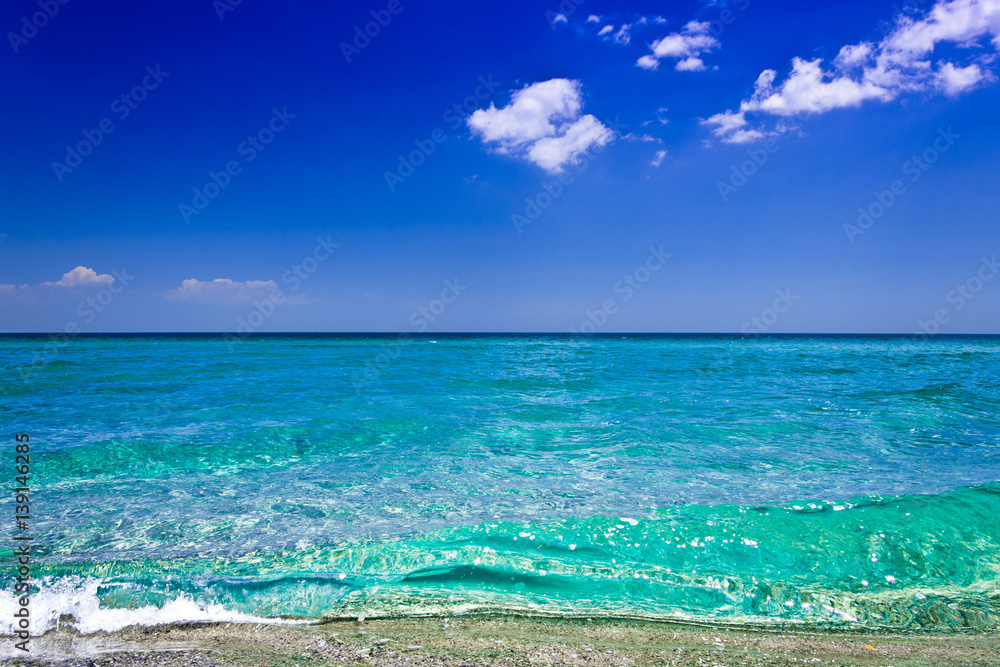 Wild beach with clear water and blue sky in summer